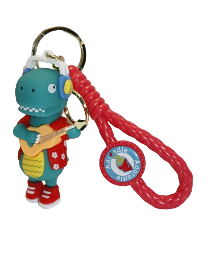 BRELOK DINOZAUR W SŁUCHAWKACH Z GITARĄ Z DESKOROLKĄ 8CM GUMOWY E1946 EMAJ